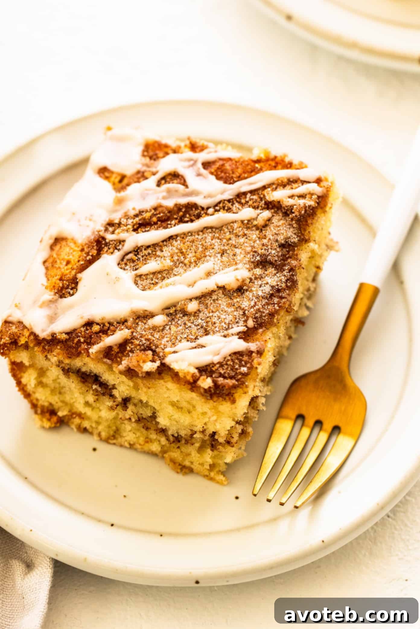 A slice of sour cream coffee cake on a plate with a fork