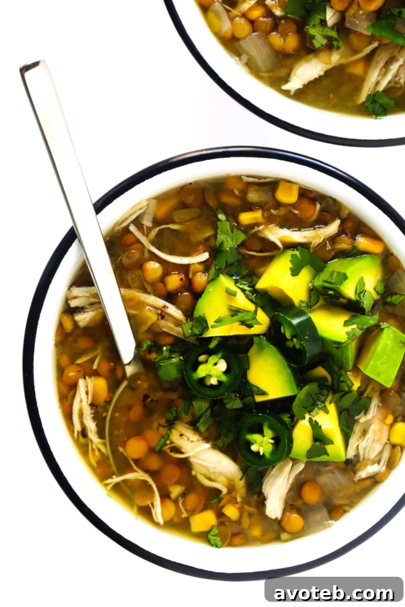 Mexican Chicken Lentil Soup served in a bowl, garnished with fresh avocado and cilantro.