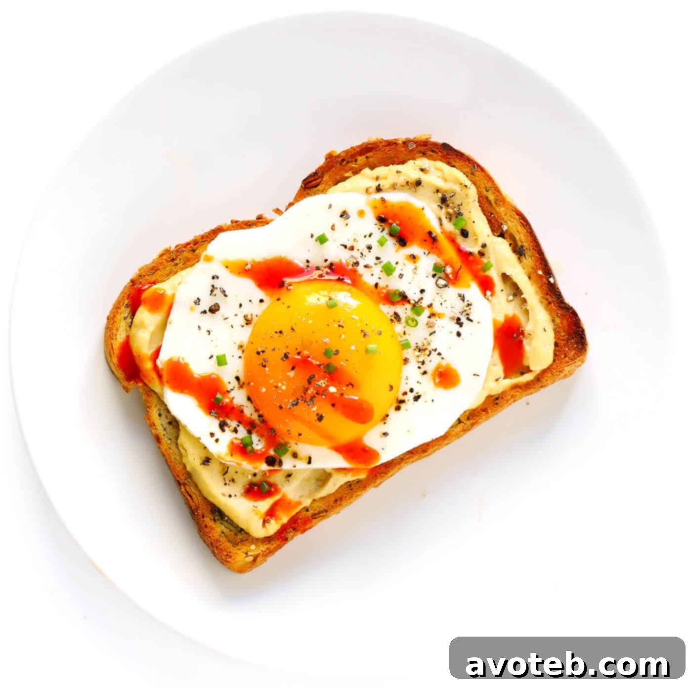 Hummus Toast topped with a perfectly fried egg and fresh chives.