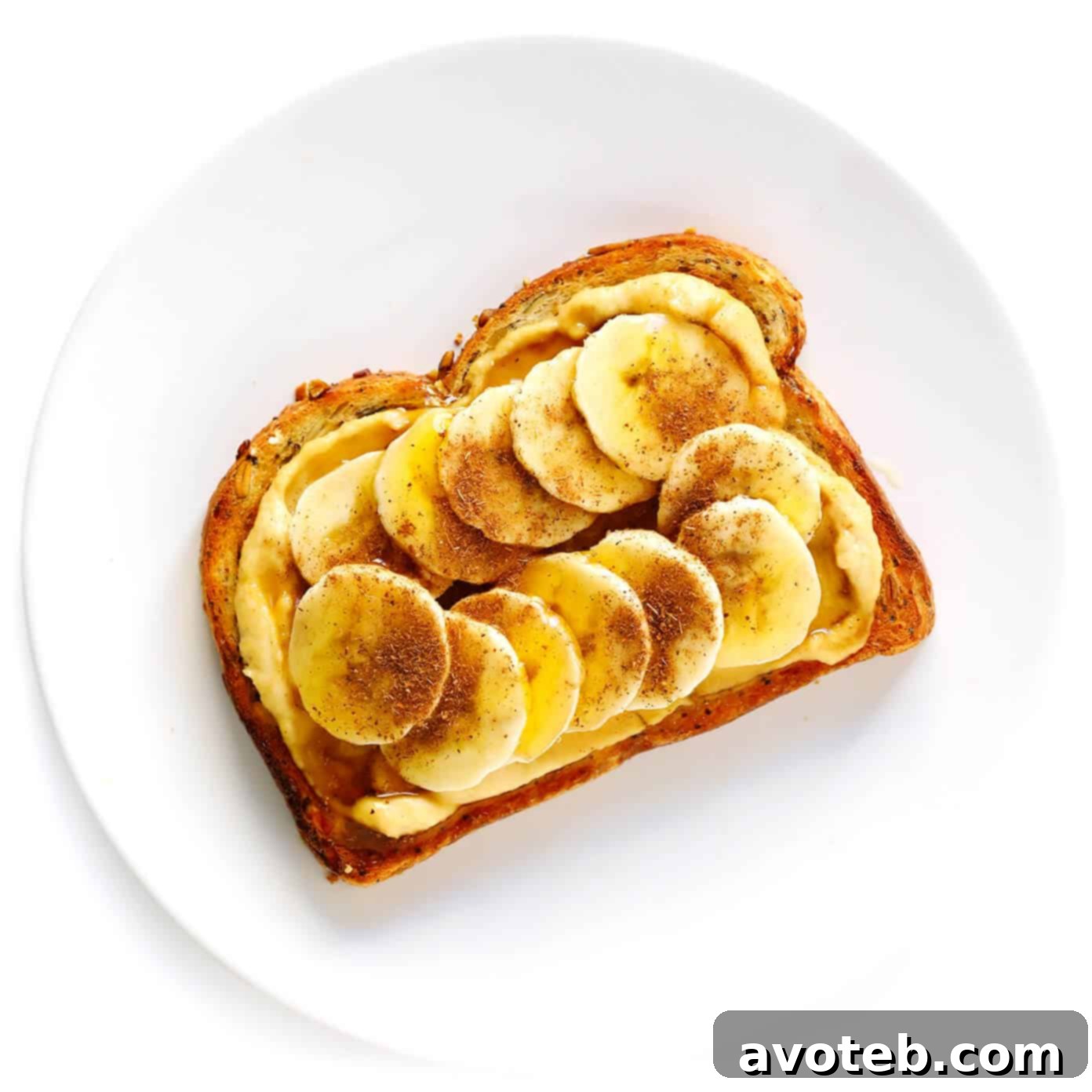Sweet Hummus Toast with sliced bananas, a drizzle of honey, and a sprinkle of cinnamon.