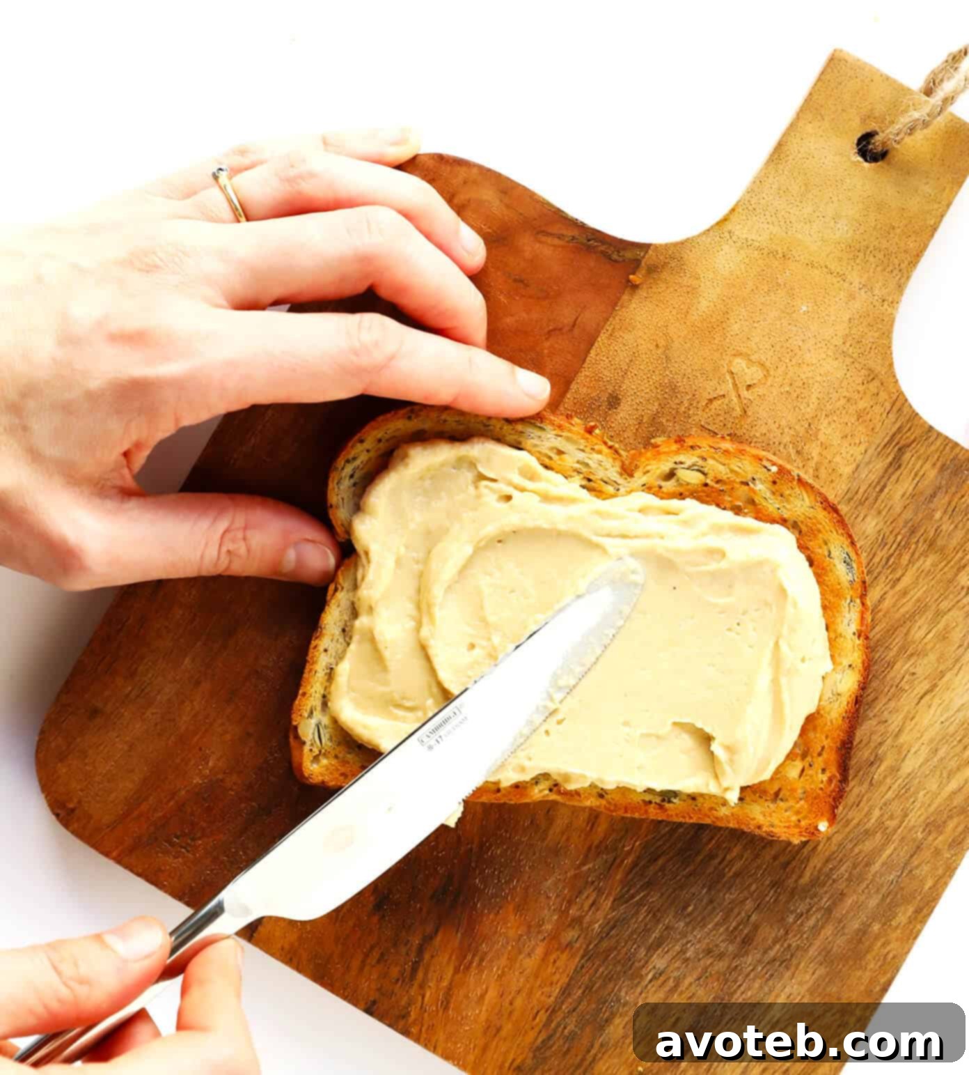 Step-by-step process of making hummus toast: toasting bread, spreading hummus, and adding toppings.