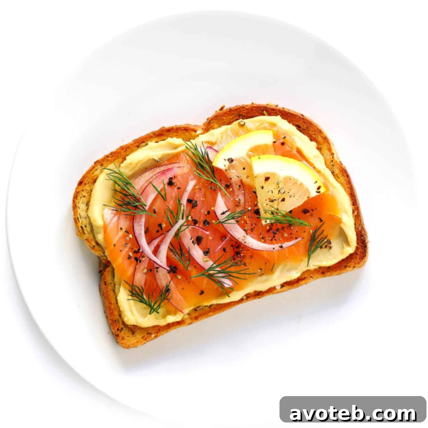 Hummus Toast topped with delicate lox (smoked salmon), capers, and red onion.