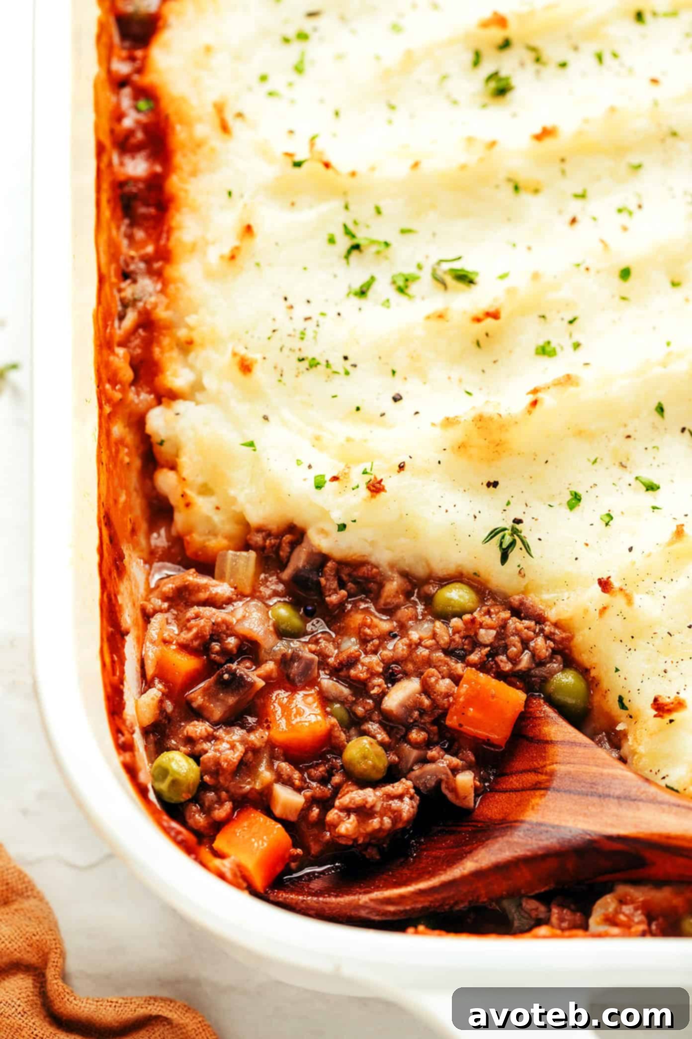 Golden Crowned Comfort Bake 6 A generous serving of Shepherd's Pie on a plate, garnished with fresh herbs