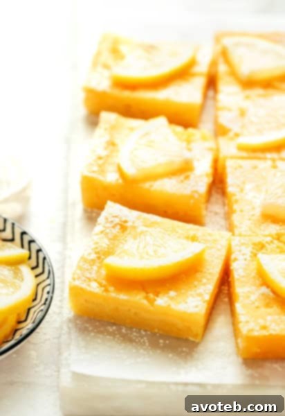 5-Ingredient Lemon Bars with powdered sugar and lemon slices