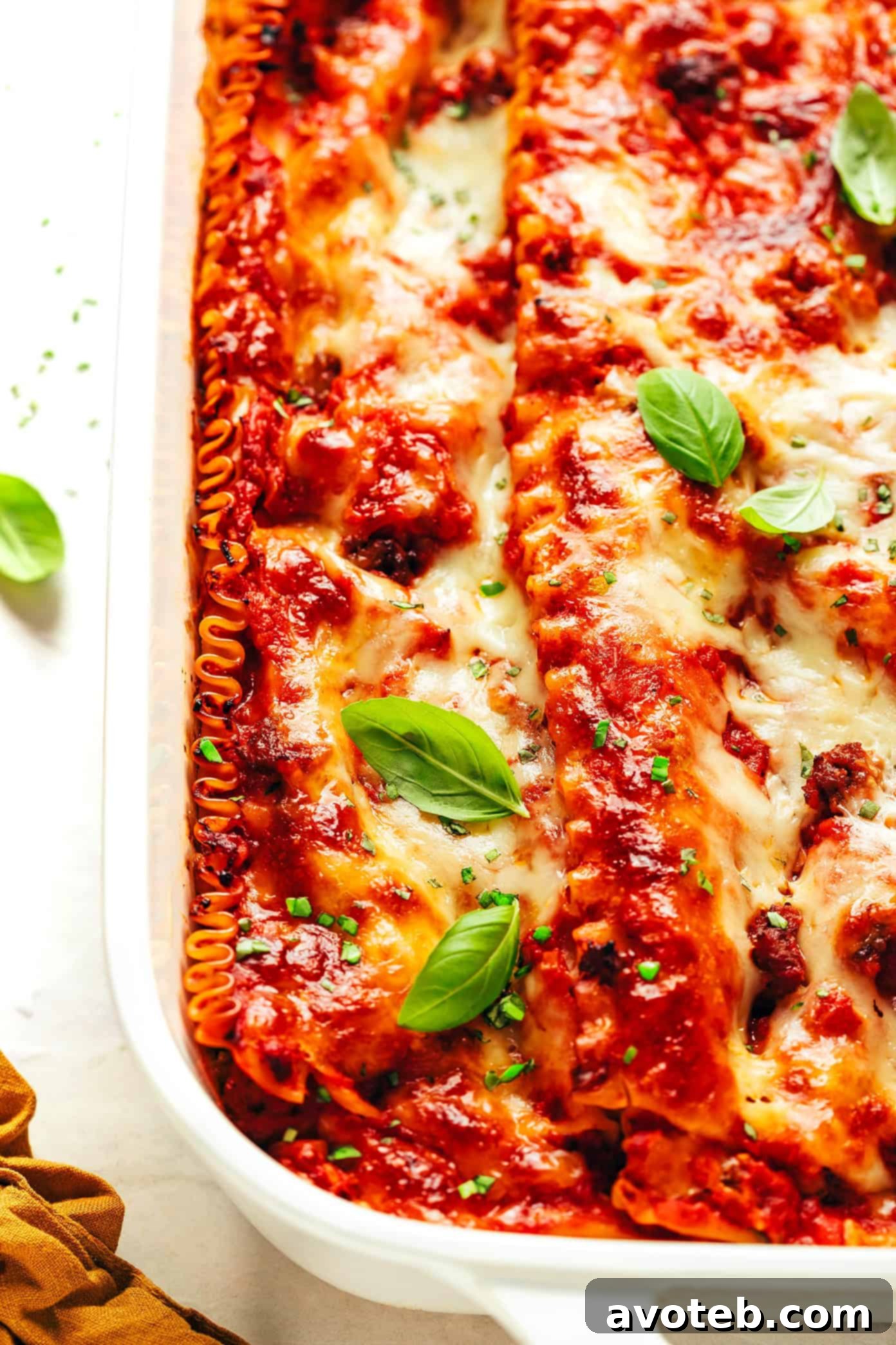 A stunning overhead shot of the baked lasagna, highlighting the golden cheese and fresh basil, ready to be served.
