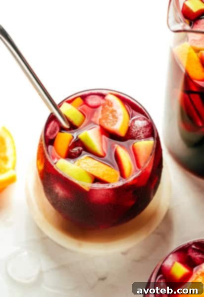 A vibrant pitcher of sangria with sliced fruit, ready to be poured into glasses.