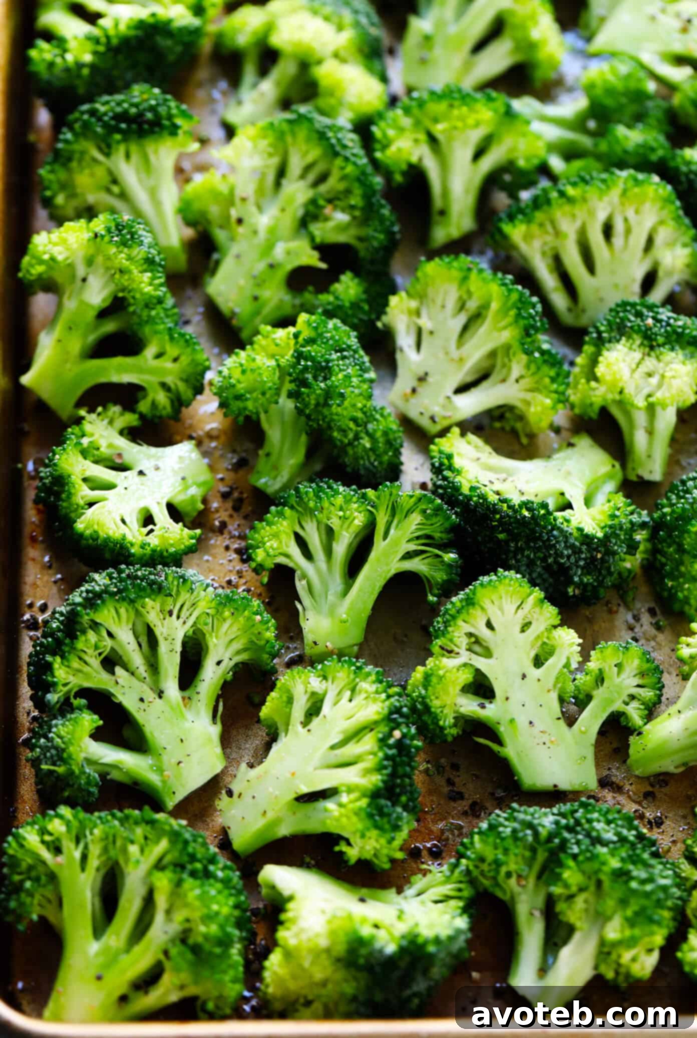 Raw broccoli florets, perfectly cut into bite-sized pieces and ready for roasting, displayed on a clean surface.