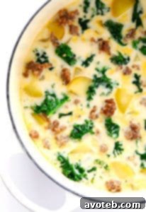 A close-up of a serving of Zuppa Toscana soup in a rustic bowl, garnished with crumbled bacon, showcasing its rich, creamy texture and vibrant colors from the kale and potatoes.