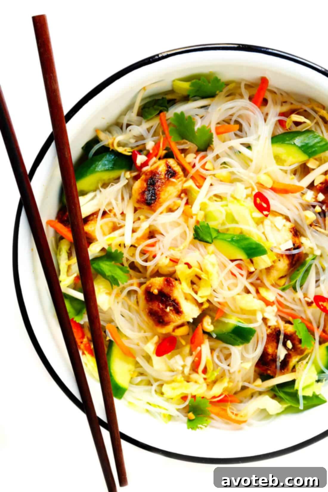 Vietnamese Chicken Noodle Salad: A close-up view of a vibrant bowl featuring grilled chicken, fresh herbs, crisp vegetables, and delicate vermicelli noodles, dressed with a light, zesty Nuoc Cham sauce.