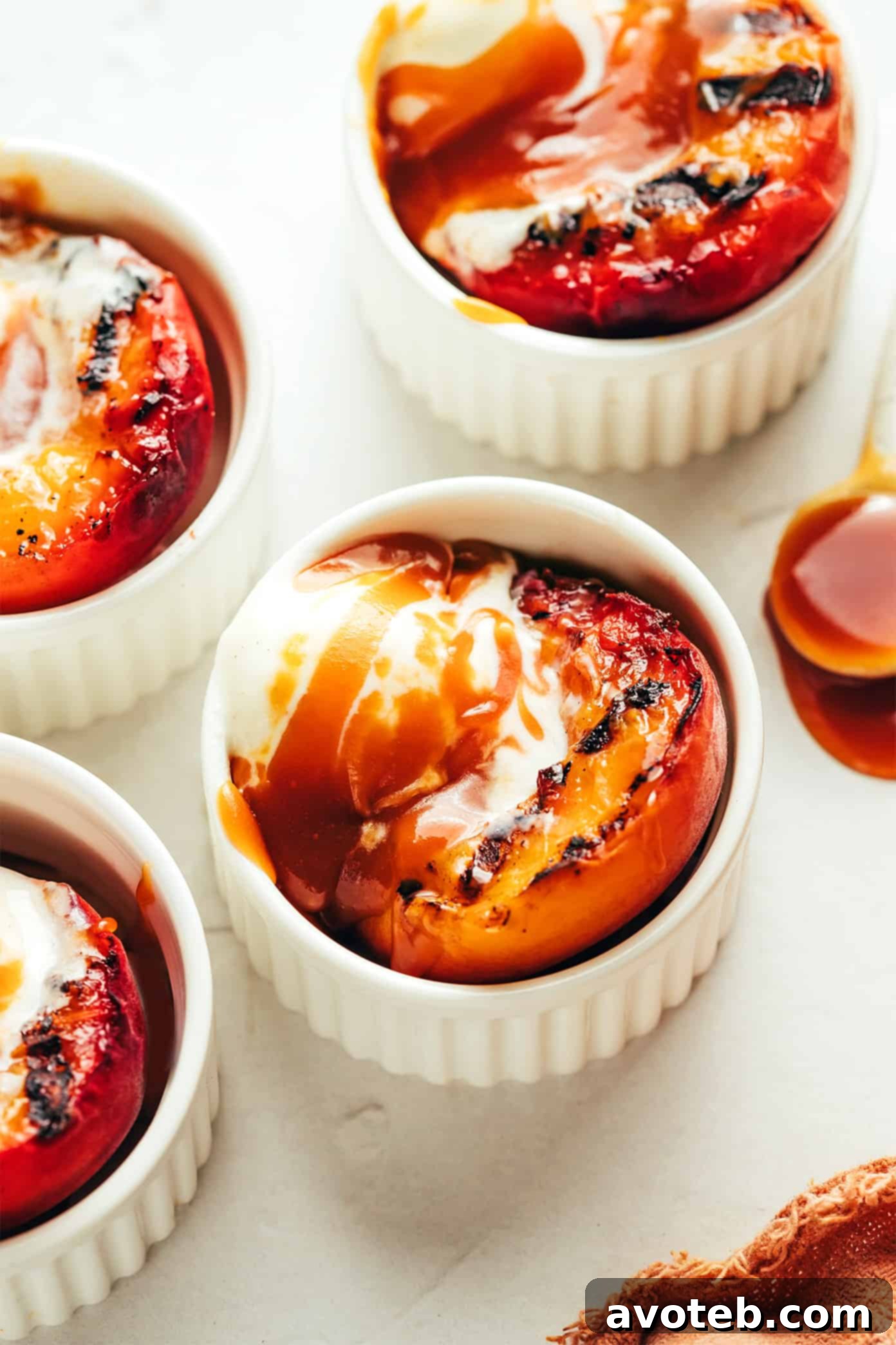 Close-up of grilled peach halves with caramel sauce and melting ice cream
