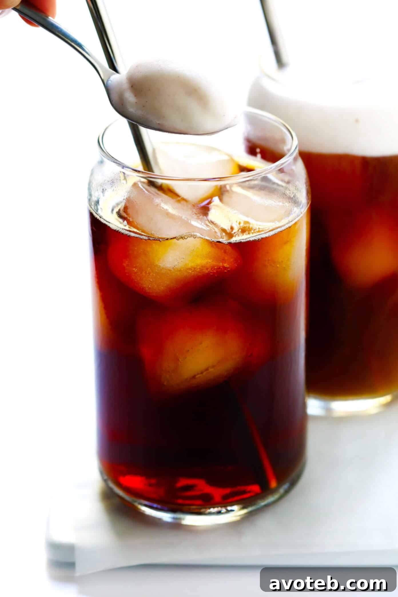 Pumpkin Cream Cold Brew with a captivating view of the creamy foam and distinct iced coffee layers in a glass