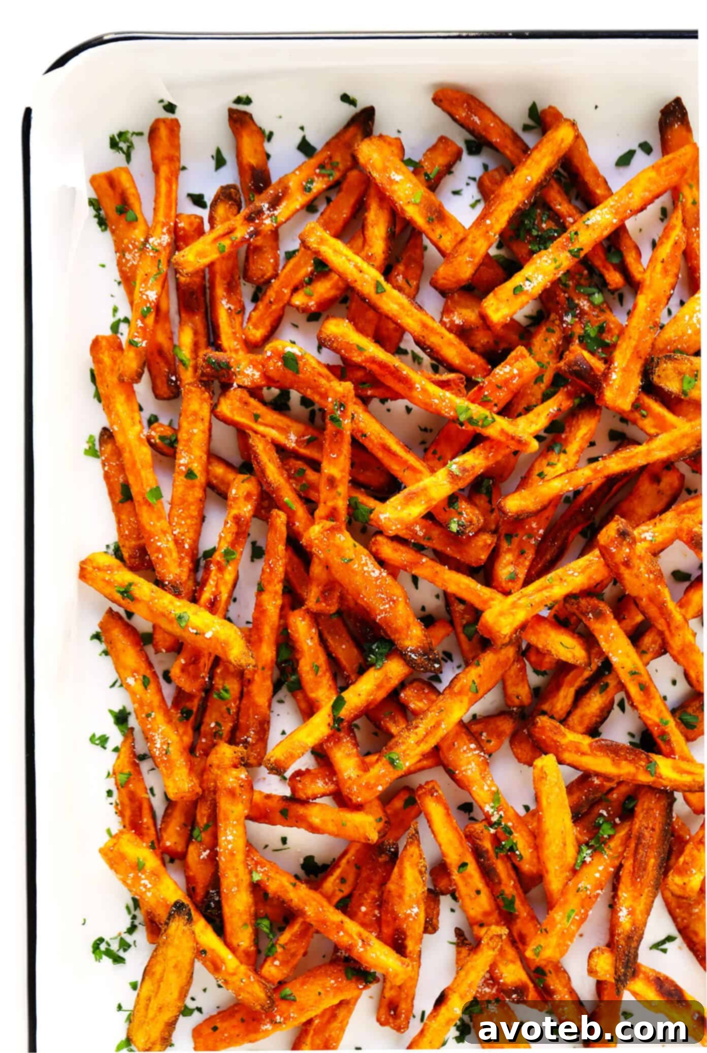 The BEST Crispy Baked Sweet Potato Fries Recipe - Golden brown and perfectly seasoned sweet potato fries on a baking sheet, ready to be served.