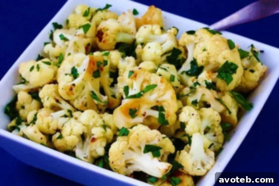 Delicious Garlic Roasted Cauliflower with herbs and lemon, served on a plate