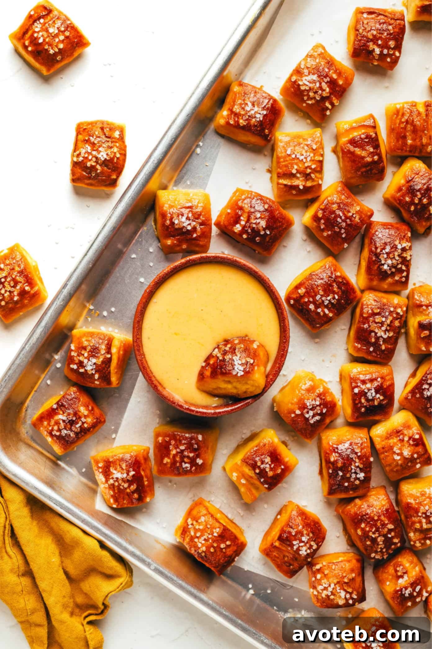 A close-up shot of golden brown, buttery soft pretzel bites piled high, ready to be served.