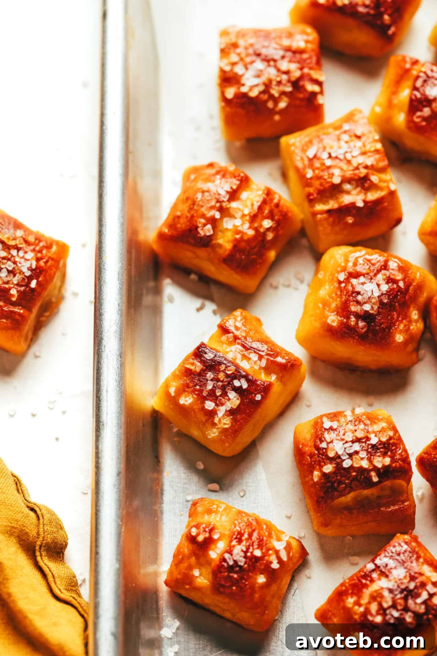 A baking sheet filled with golden soft pretzel bites, freshly baked and still warm, ready for enjoyment.