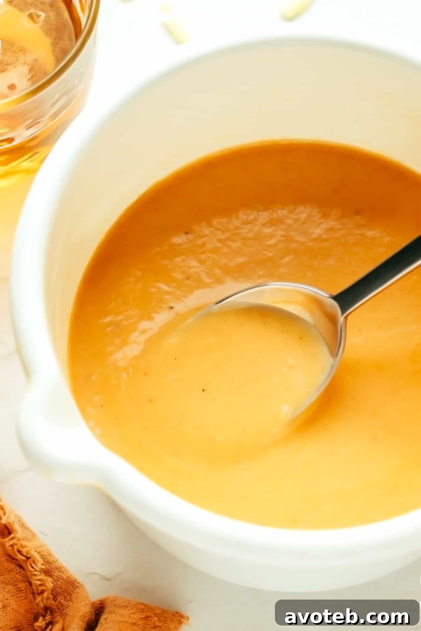 Creamy Beer Cheese Dip served in a small bowl with pretzel bites around it.
