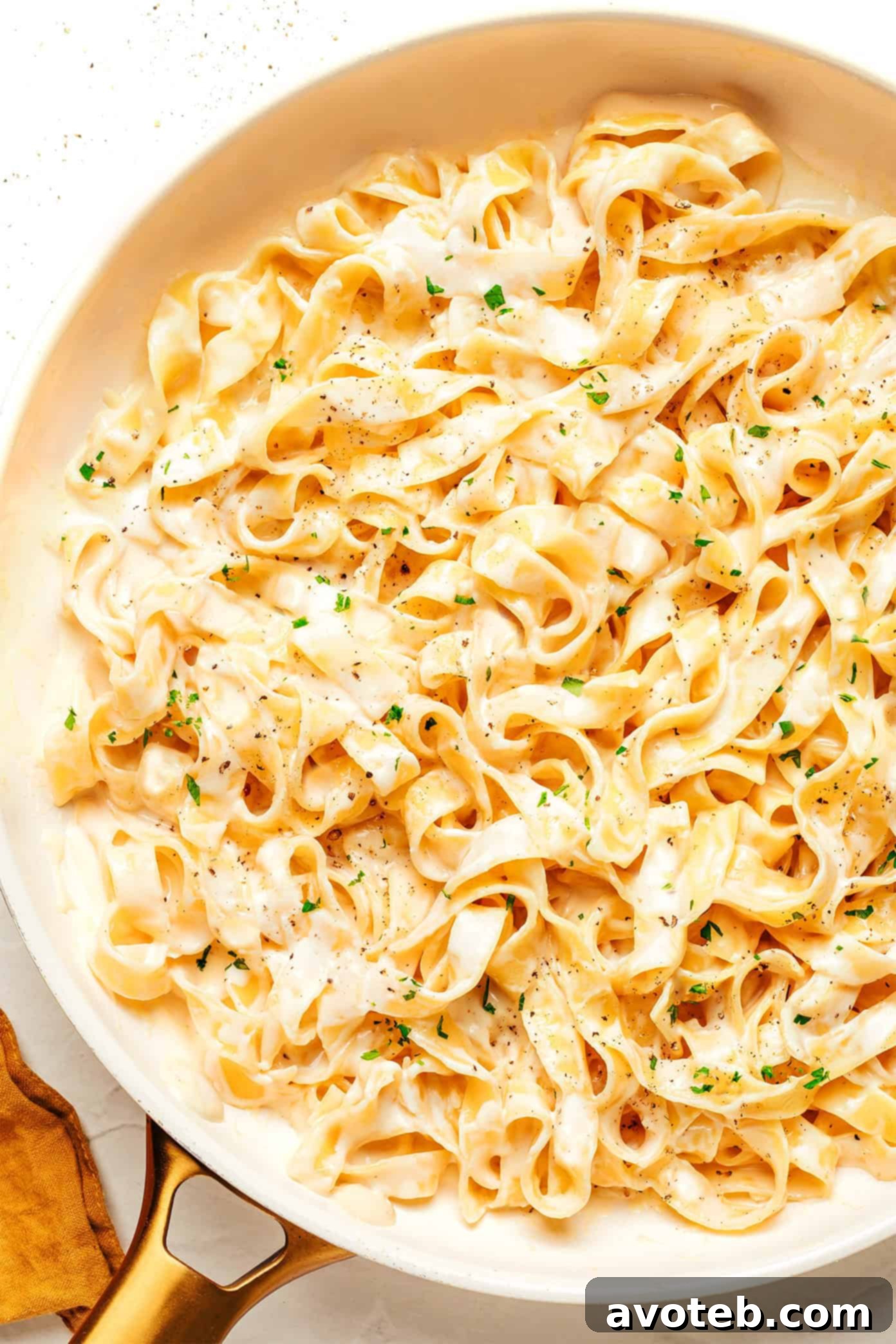 A bowl of creamy Alfredo sauce garnished with parsley