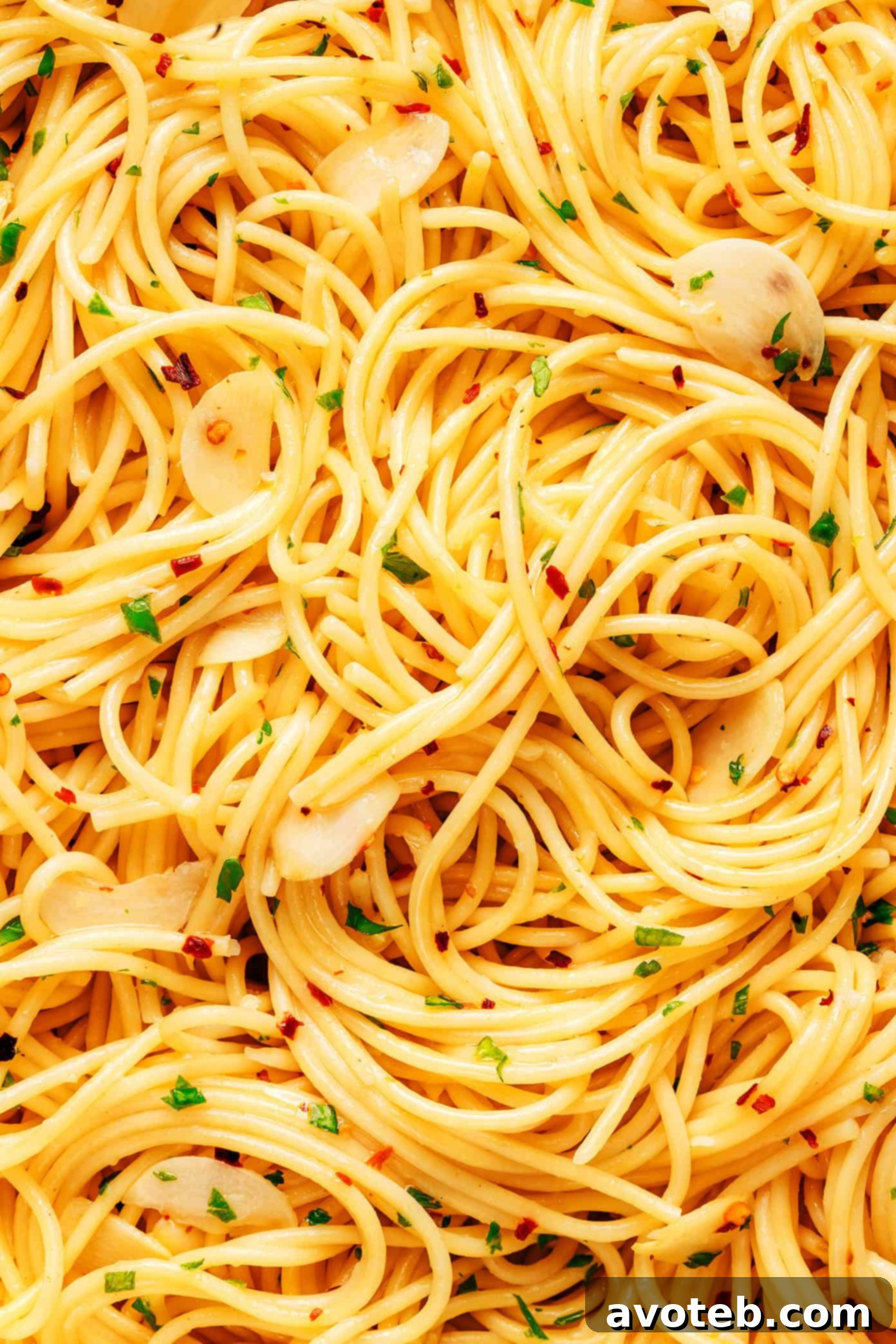 A serving of Spaghetti Aglio e Olio with a fork twirled in it, showcasing the texture and glossy sauce.