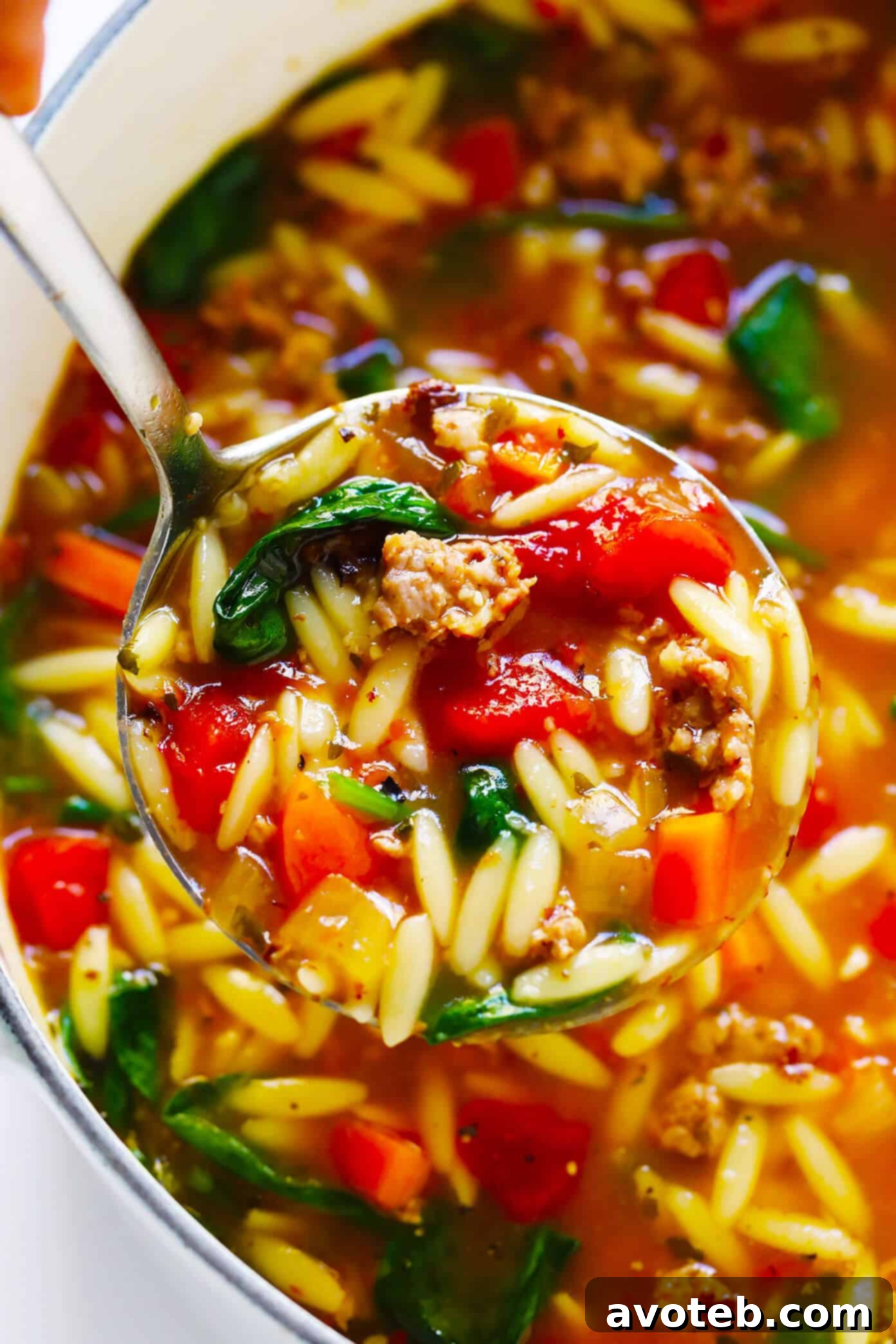 Italian Sausage Soup with Orzo and Spinach - A freshly prepared bowl of Italian Sausage and Orzo Soup, ready to be enjoyed, garnished with fresh herbs and Parmesan cheese.