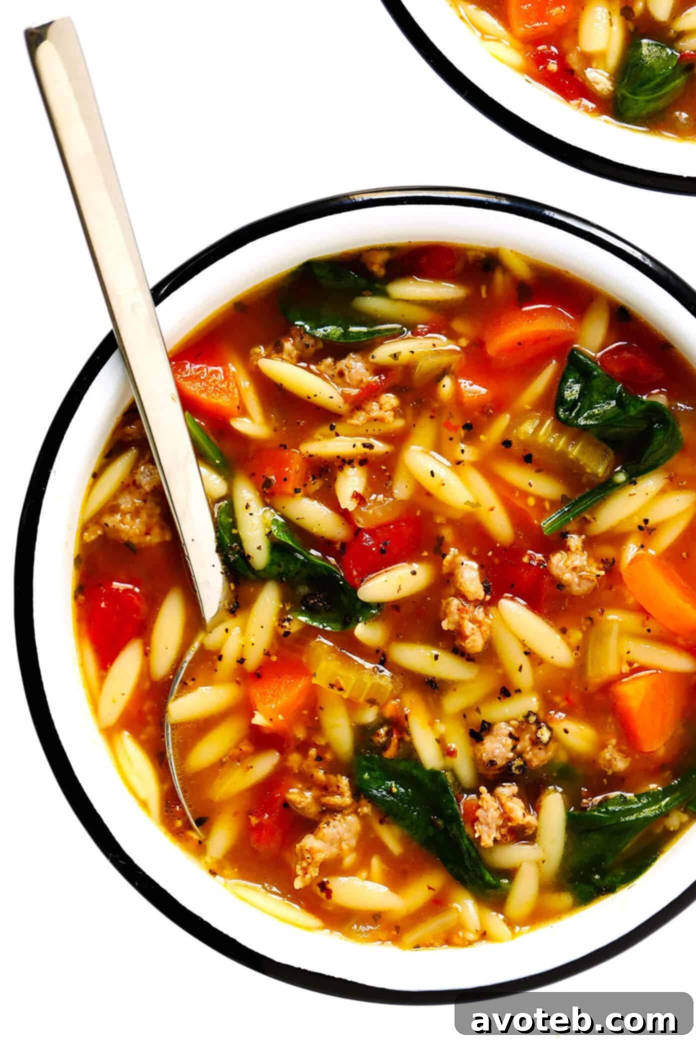 Italian Sausage, Orzo, Spinach and Tomato Soup - A generous serving of the finished soup, garnished with fresh basil and Parmesan cheese, highlighting its rich textures and inviting aroma.