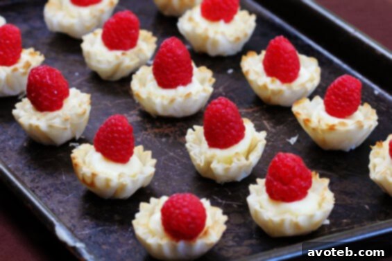 Close-up of baked Brie and Raspberry Phyllo Cups, golden brown and glistening.