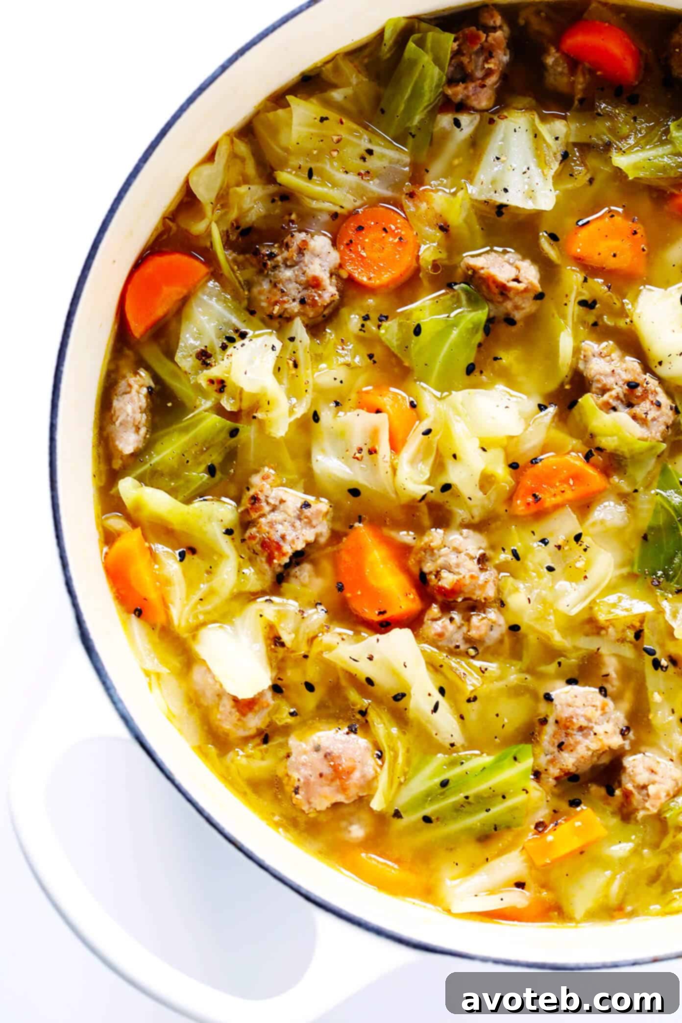 This Egg Roll Soup recipe is SO tasty!! It's basically an Asian cabbage soup, simmered with zesty sausage, carrots, sesame and ginger, and topped with crispy wonton strips if desired. It's the perfect easy dinner recipe. | Gimme Some Oven #glutenfree #soup #recipe #gf
