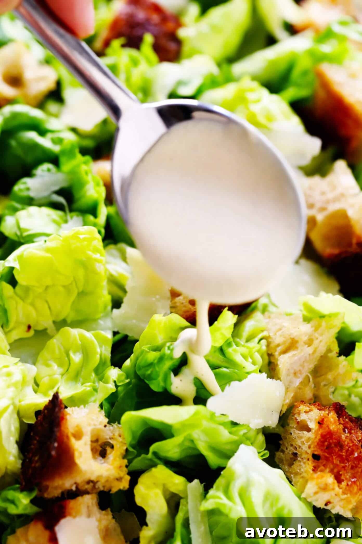 Caesar Dressing drizzled over a fresh Caesar salad with croutons