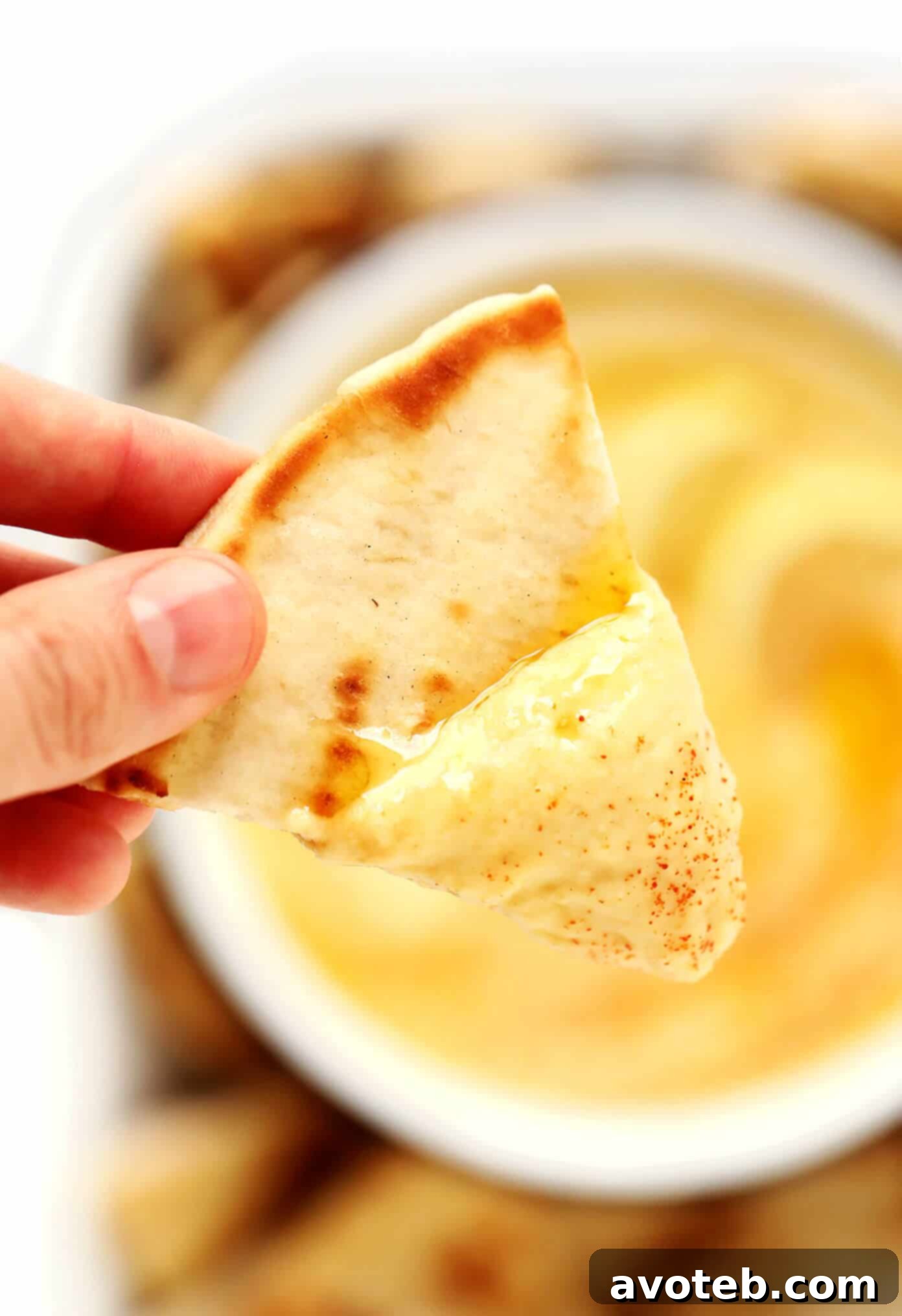 Closeup of Greek Fava Dip with pita bread, showing creamy texture and garnishes.