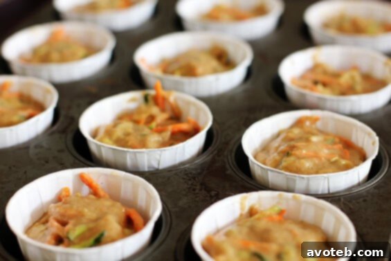 Close-up of baked carrot zucchini muffins, showing their fluffy texture and vegetable bits.