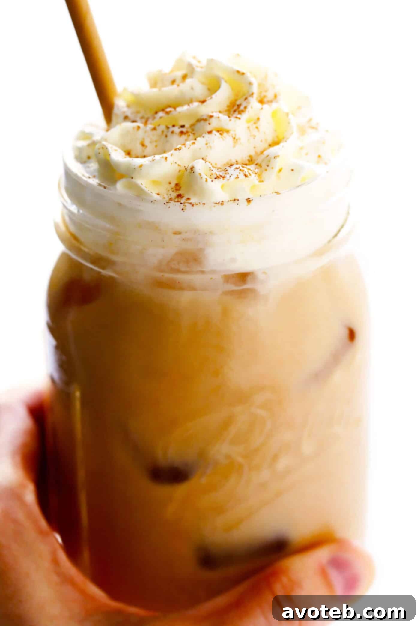 Iced Pumpkin Spice Latte topped with a generous swirl of whipped cream and a sprinkle of spice
