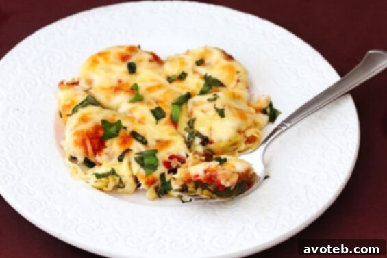 Close-up of baked Zucchini Parmesan with melted cheese and fresh basil