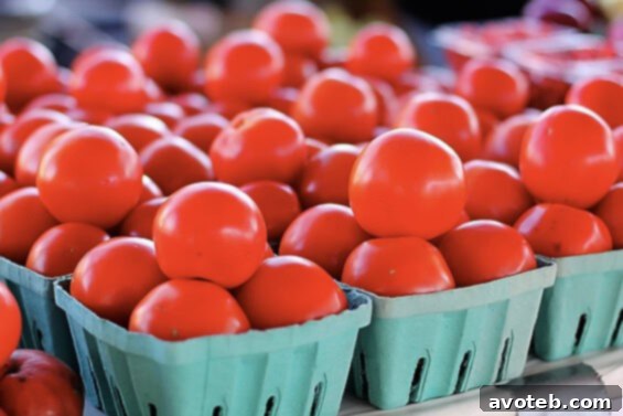 Fresh tomatoes, with delightful samples for tasting Pristine, ripe red tomatoes arranged for sale, many with samples available