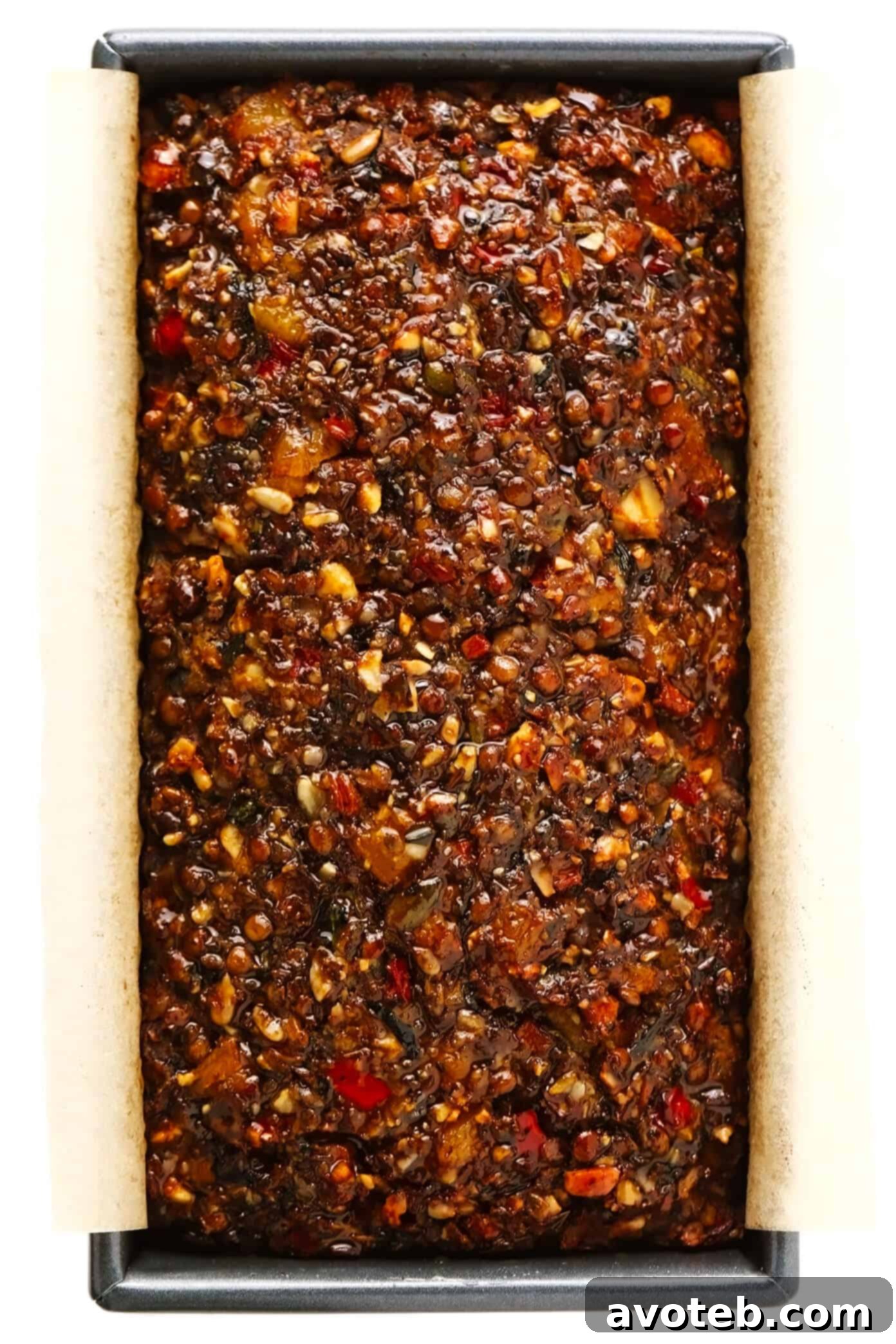 This Nut Roast recipe is packed with a deliciously sweet and savory blend of nuts, veggies, lentils, dried apricots and fresh rosemary and sage. It's easy to prep in advance, naturally gluten-free + vegetarian + vegan, and absolutely delicious served with cranberry sauce and/or gravy. Perfect for the holidays (especially Christmas, Thanksgiving or Easter) or Sunday dinner! | gimmesomeoven.com #nutroast #vegetarian #vegan #glutenfree #healthy #dinner #christmas #holiday Nut Roast baking in a bread pan, golden brown and ready to rest