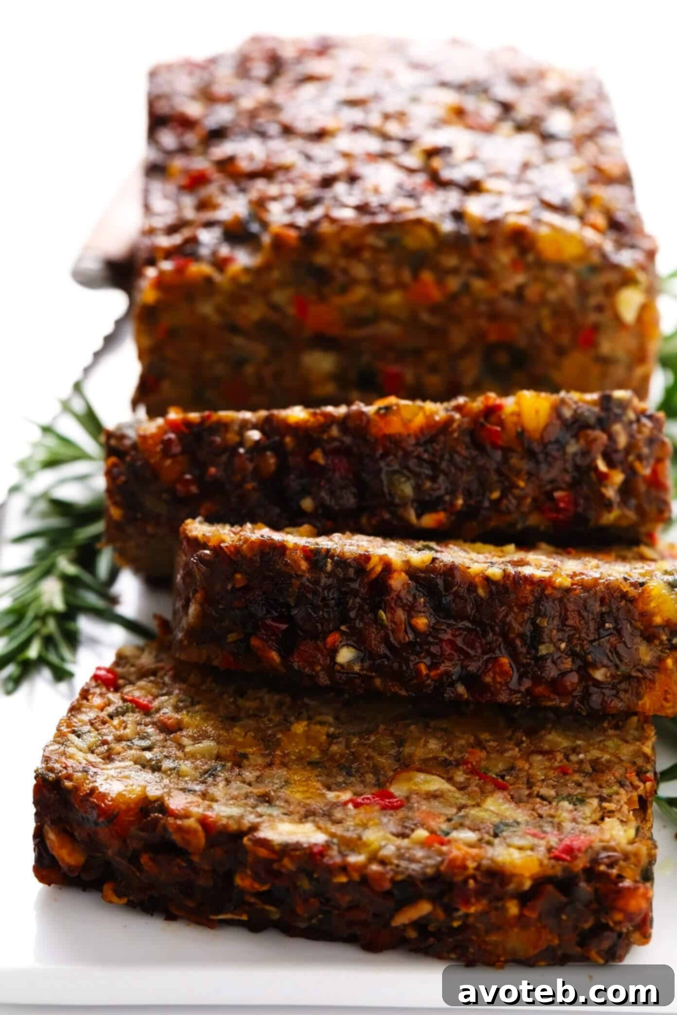 This Nut Roast recipe is packed with a deliciously sweet and savory blend of nuts, veggies, lentils, dried apricots and fresh rosemary and sage. It's easy to prep in advance, naturally gluten-free + vegetarian + vegan, and absolutely delicious served with cranberry sauce and/or gravy. Perfect for the holidays (especially Christmas, Thanksgiving or Easter) or Sunday dinner! | gimmesomeoven.com #nutroast #vegetarian #vegan #glutenfree #healthy #dinner #christmas #holiday Nut Roast sliced and ready to serve, revealing its vibrant, nutty interior
