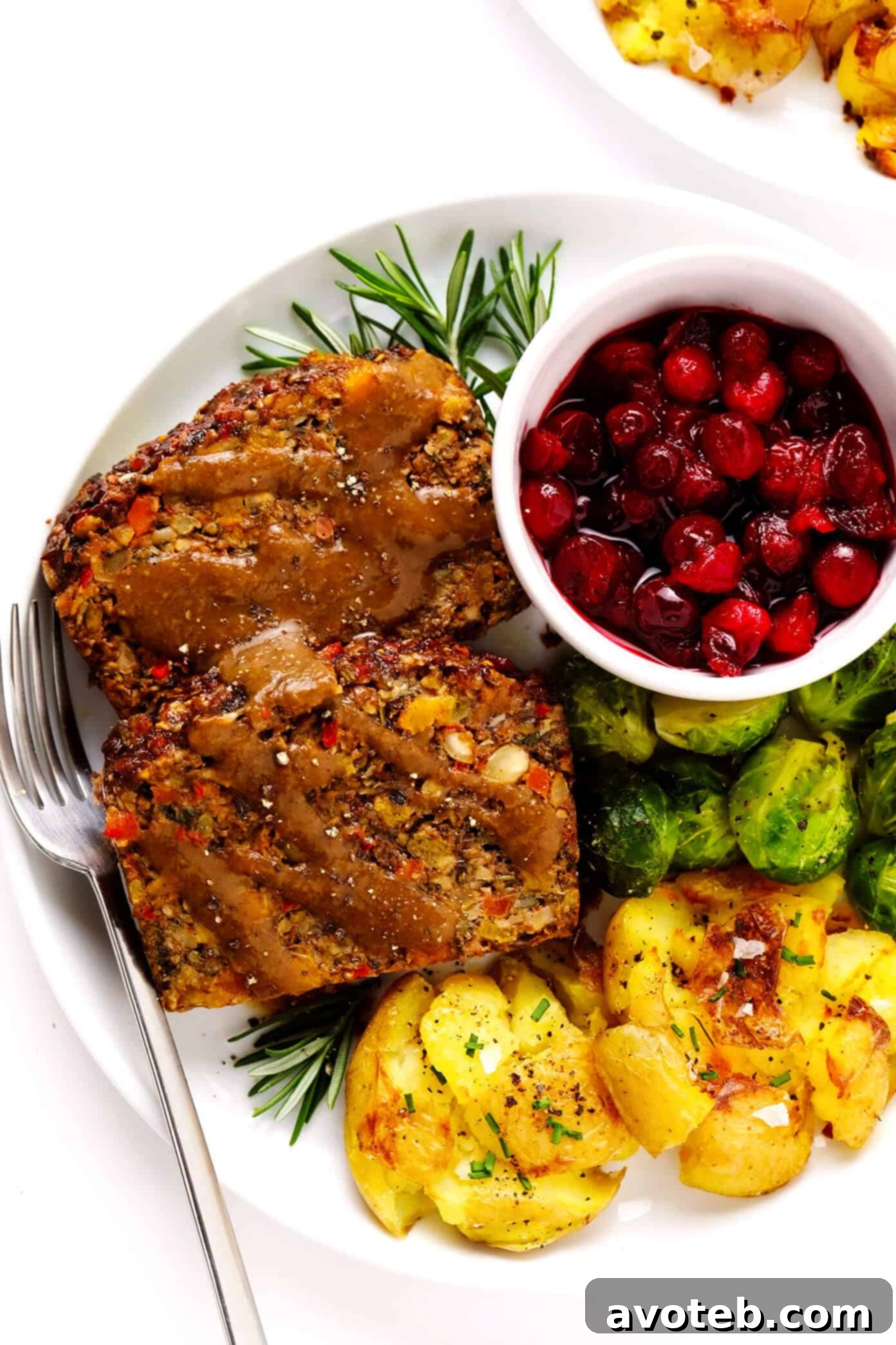 This Nut Roast recipe is packed with a deliciously sweet and savory blend of nuts, veggies, lentils, dried apricots and fresh rosemary and sage. It's easy to prep in advance, naturally gluten-free + vegetarian + vegan, and absolutely delicious served with cranberry sauce and/or gravy. Perfect for the holidays (especially Christmas, Thanksgiving or Easter) or Sunday dinner! | gimmesomeoven.com #nutroast #vegetarian #vegan #glutenfree #healthy #dinner #christmas #holiday Festive Nut Roast served with mushroom gravy, smashed potatoes, roasted Brussels sprouts, and cranberry sauce