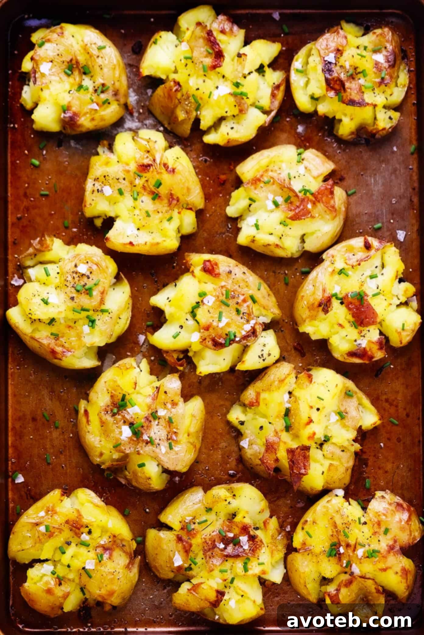 Crispy Smashed Potatoes 2 Deliciously crispy smashed potatoes on a baking sheet, garnished with fresh herbs.