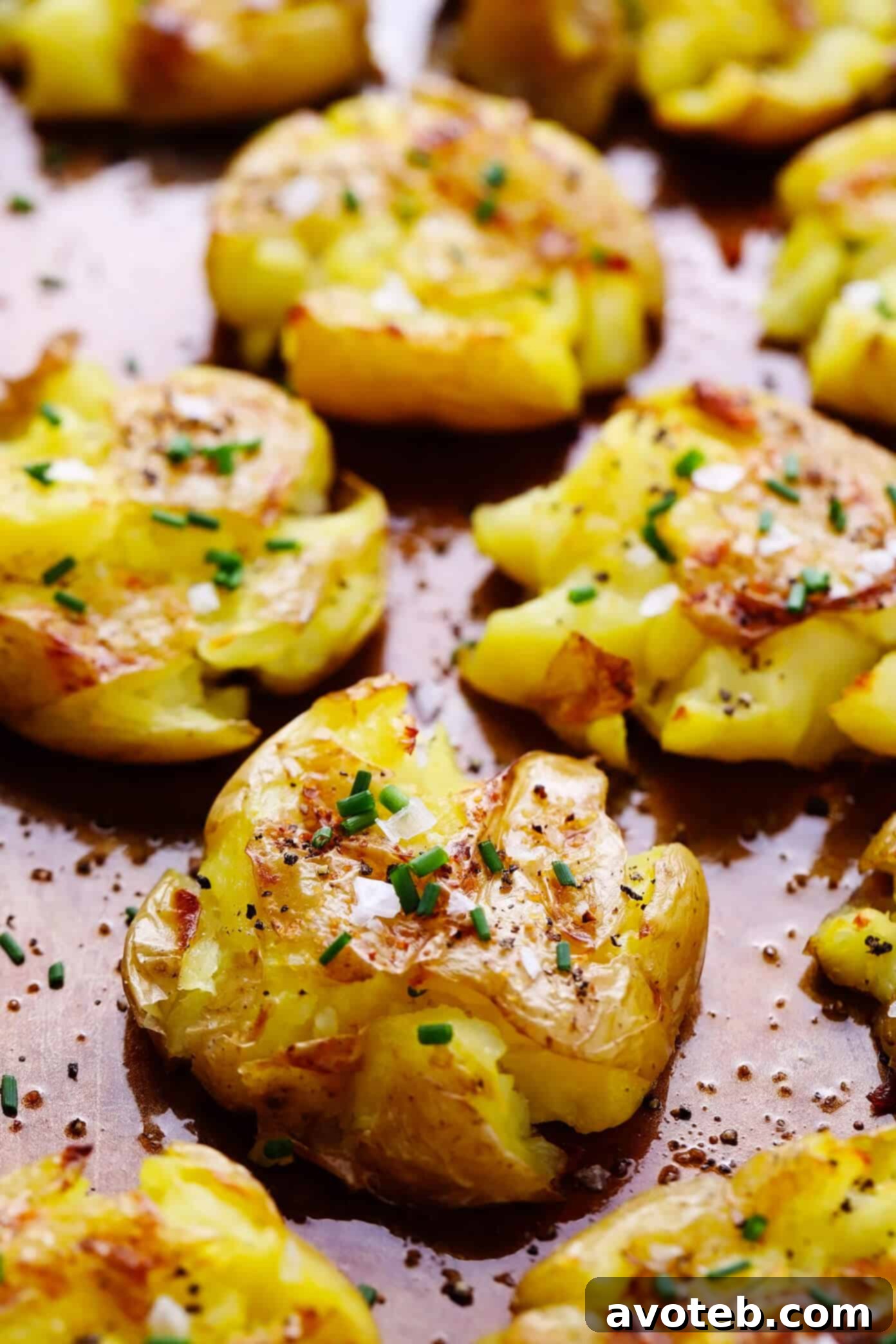 Crispy Smashed Potatoes 5 A close-up of crispy garlic smashed potatoes on a baking sheet, freshly baked and golden brown.