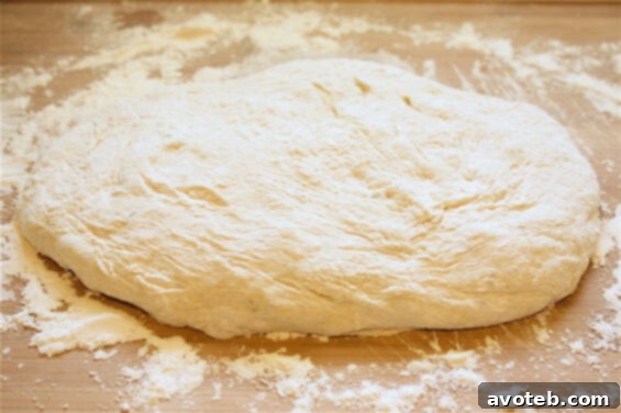 Close-up of freshly prepared pizza dough on a wooden surface, ready for toppings