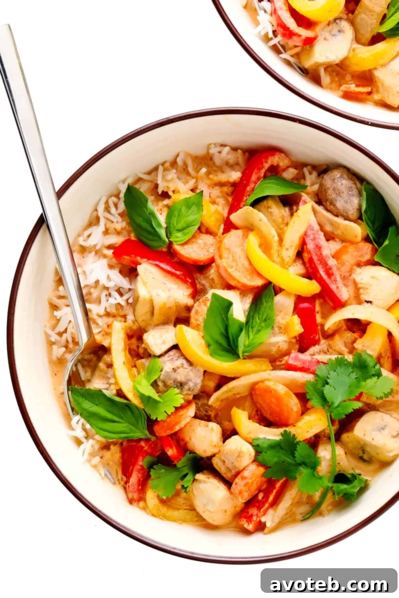 A stunning overhead shot of a single serving of Thai Chicken Red Curry, showcasing the rich sauce, tender chicken, and colorful vegetables, garnished with fresh herbs.
