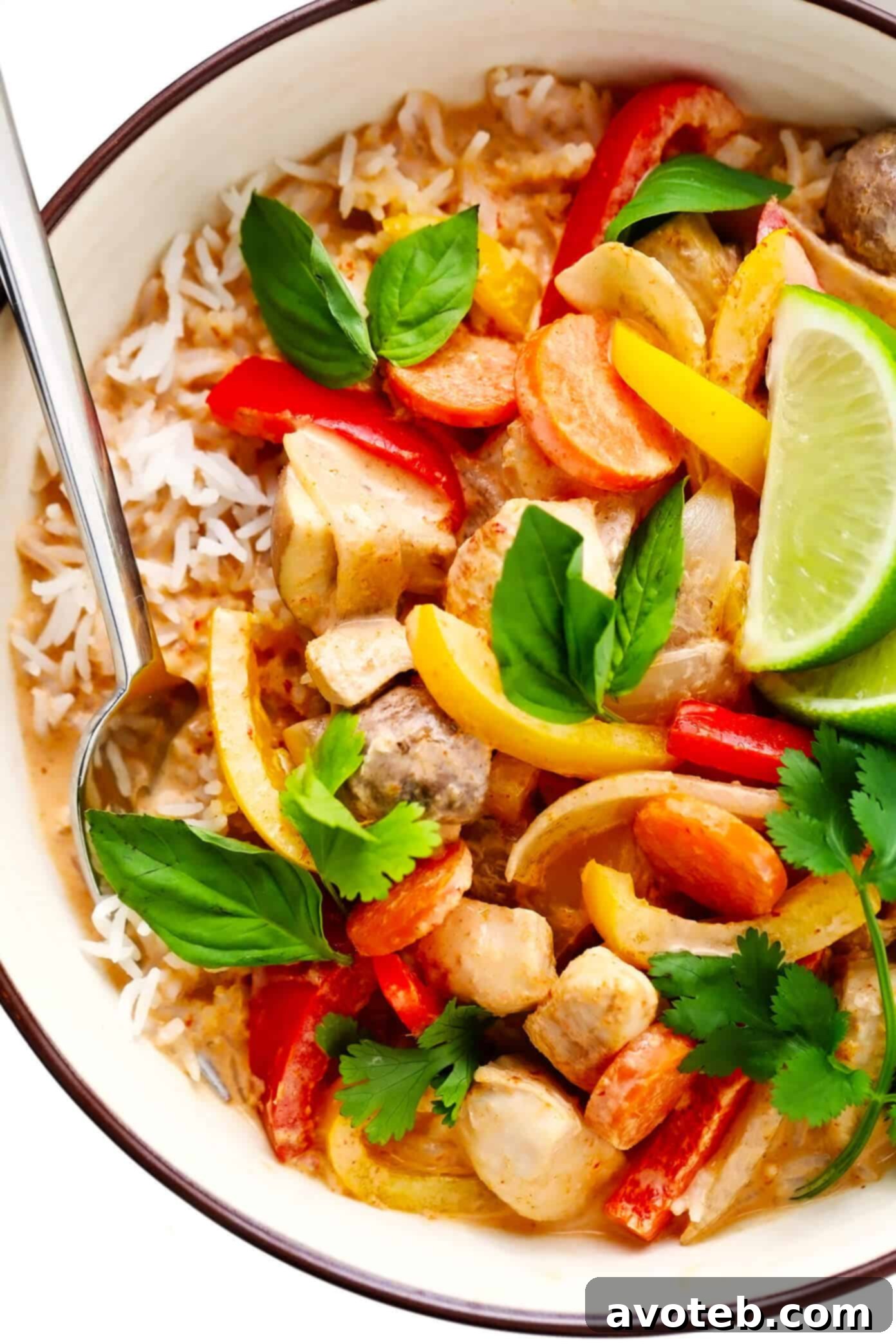 A close-up shot of Thai Chicken Red Curry with fluffy white rice, showcasing the texture of the chicken, vegetables, and rich sauce.
