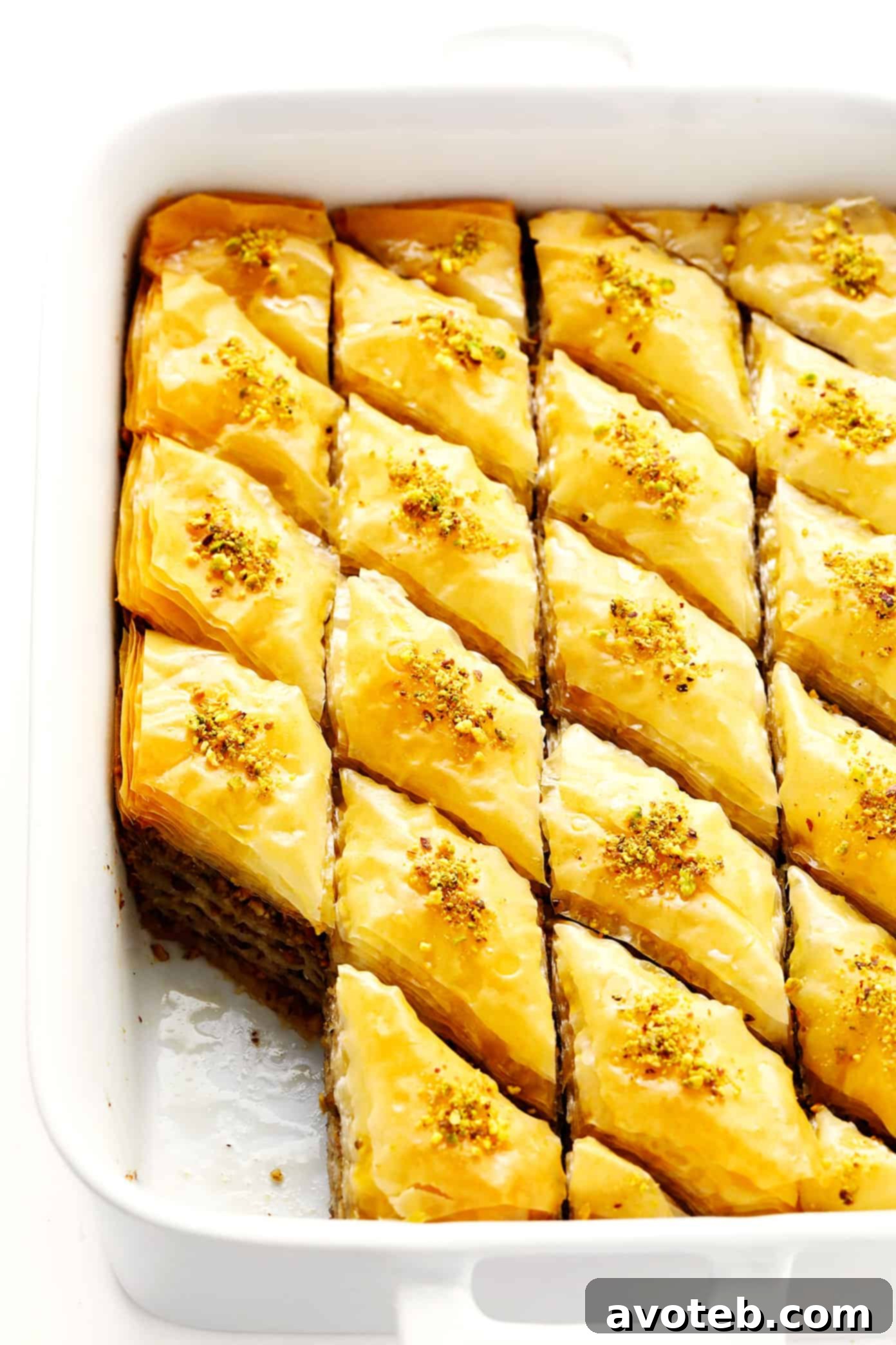 A large pan of freshly baked homemade baklava, glistening with syrup and topped with chopped nuts, ready to be served.