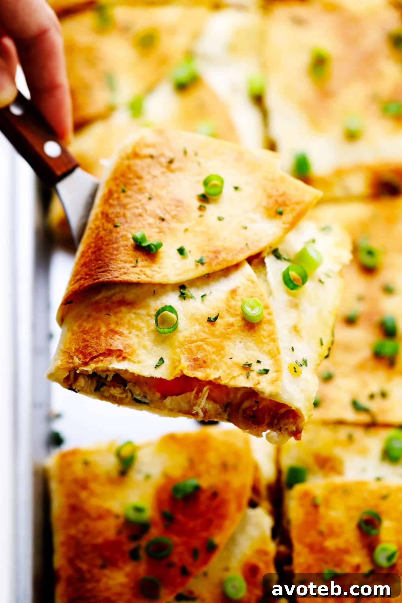 This party-sized chicken sheet pan quesadilla recipe is filled with a zesty mix of cheese, beans, veggies and baked up in a large sheet pan to feed a crowd. Serve as an appetizer, dinner entrée or game day snack with guacamole, salsa, sour cream or any of your favorite dips and enjoy! | gimmesomeoven.com #chicken #quesadilla #mexican #gameday #dinner #party #appetizer #cheese A perfectly baked slice of Chicken Sheet Pan Quesadilla, showing the crispy tortilla and melted cheesy filling.