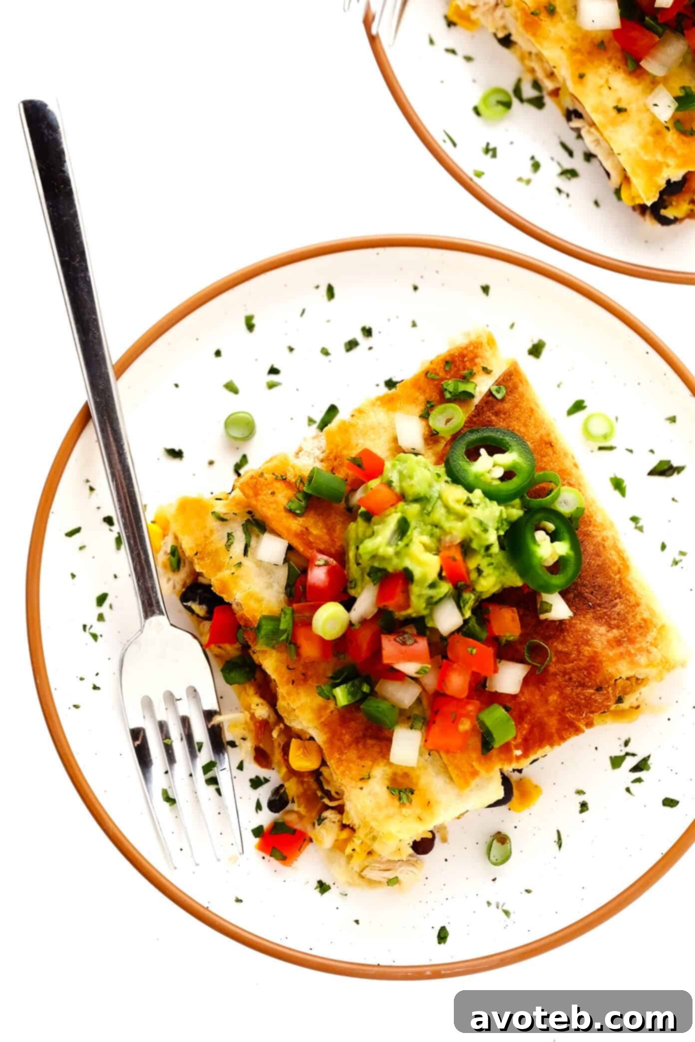 This party-sized chicken sheet pan quesadilla recipe is filled with a zesty mix of cheese, beans, veggies and baked up in a large sheet pan to feed a crowd. Serve as an appetizer, dinner entrée or game day snack with guacamole, salsa, sour cream or any of your favorite dips and enjoy! | gimmesomeoven.com #chicken #quesadilla #mexican #gameday #dinner #party #appetizer #cheese Individual serving of Chicken Sheet Pan Quesadilla beautifully presented with a side of fresh guacamole and pico de gallo.