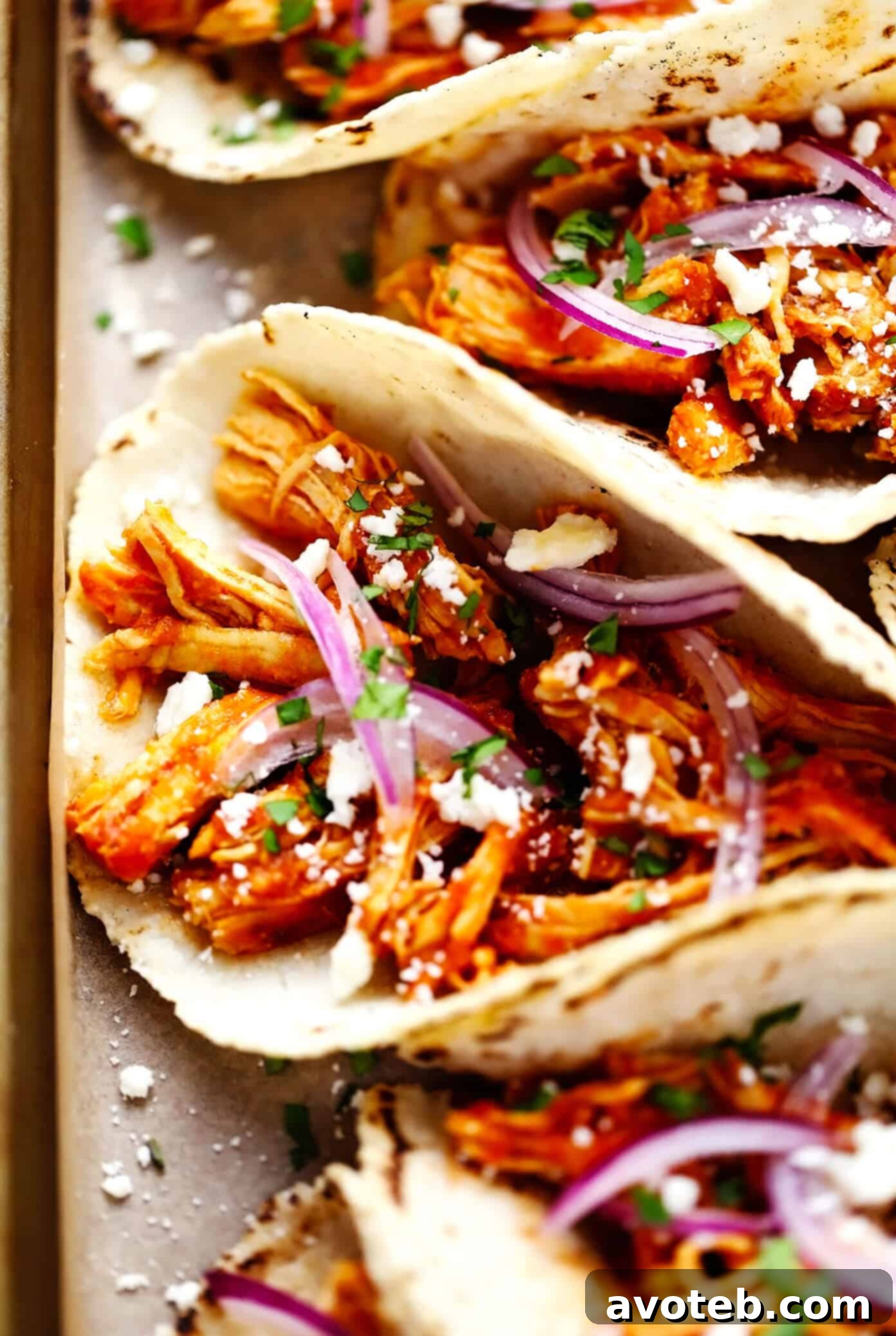 These Chicken Tinga Tacos are made with smoky chipotle chicken, served on warm corn tortillas, and loaded up with your favorite fresh toppings (such as avocado, cilantro, pickled red onions, cheese and more). Feel free to add refried beans or guacamole too, if you'd like. Always a delicious Mexican dinner recipe, and one that's ready to go in just over 30 minutes! Chicken Tinga Tacos Closeup