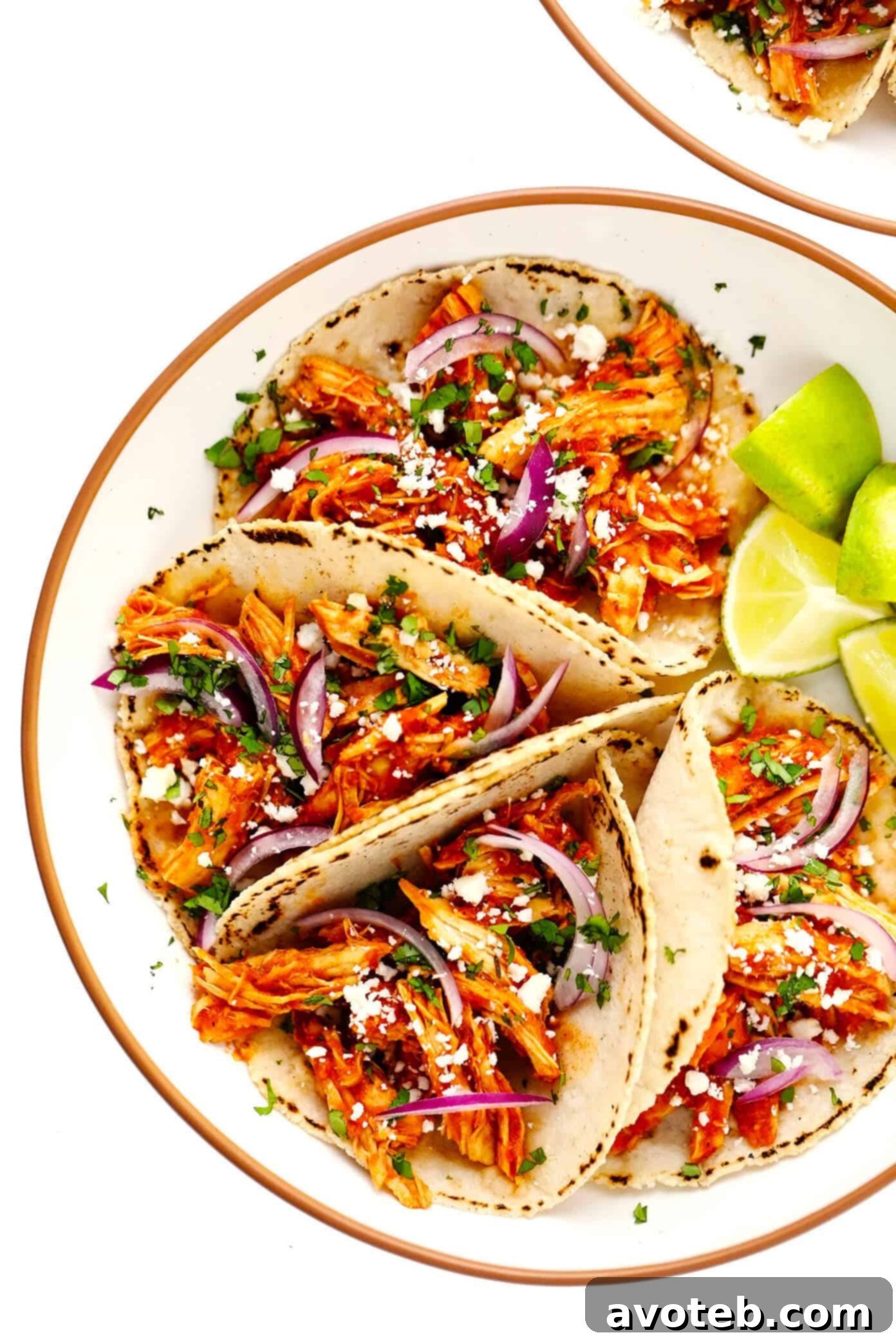 These Chicken Tinga Tacos are made with smoky chipotle chicken, served on warm corn tortillas, and loaded up with your favorite fresh toppings (such as avocado, cilantro, pickled red onions, cheese and more). Feel free to add refried beans or guacamole too, if you'd like. Always a delicious Mexican dinner recipe, and one that's ready to go in just over 30 minutes! Chicken Tinga Tacos in Bowls with Limes