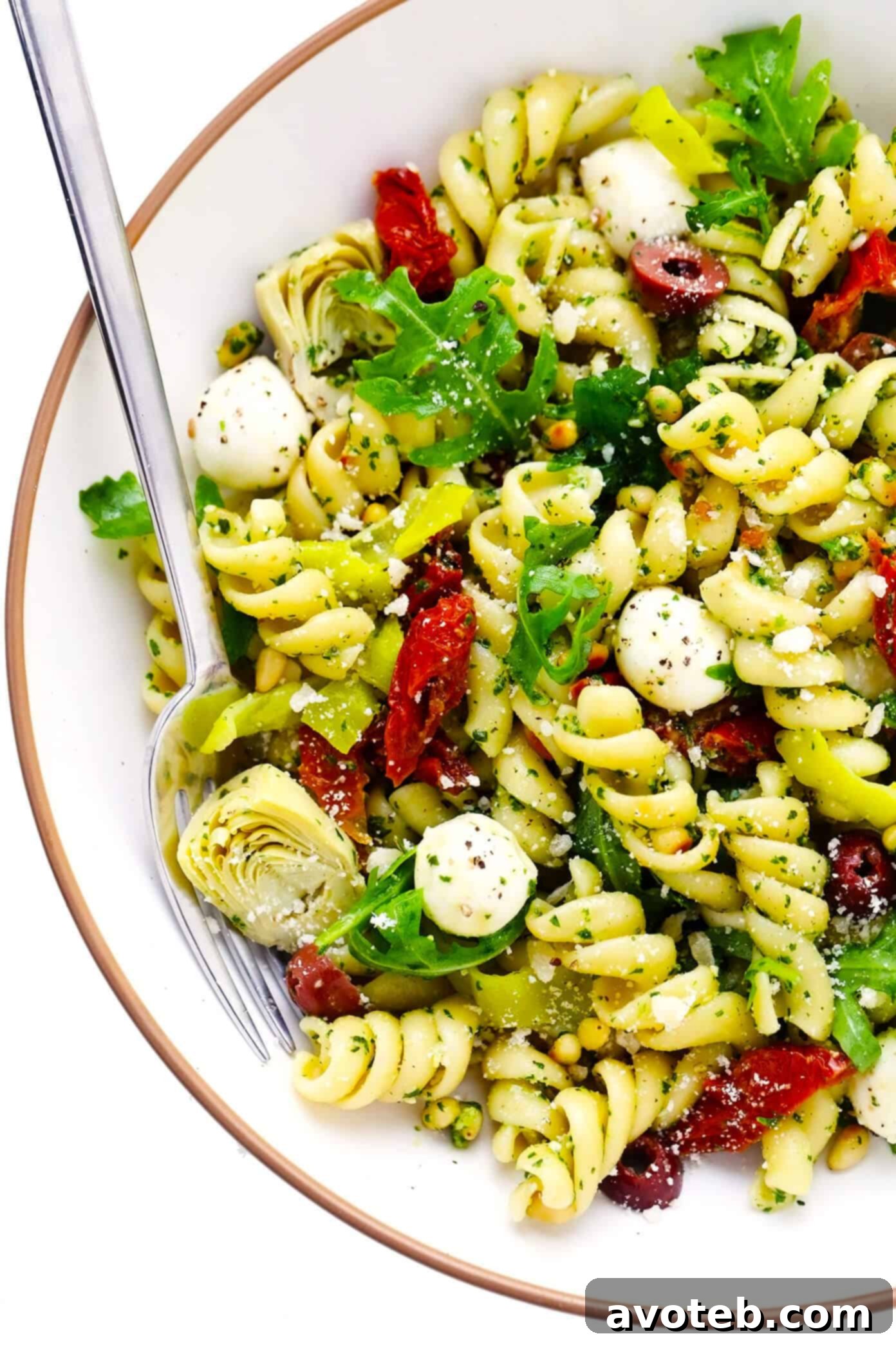 Pesto Pasta Salad in a large white bowl on a wooden table