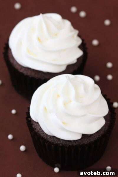 Close-up of a White Chocolate Mocha Cupcake with whipped cream frosting and chocolate shavings.