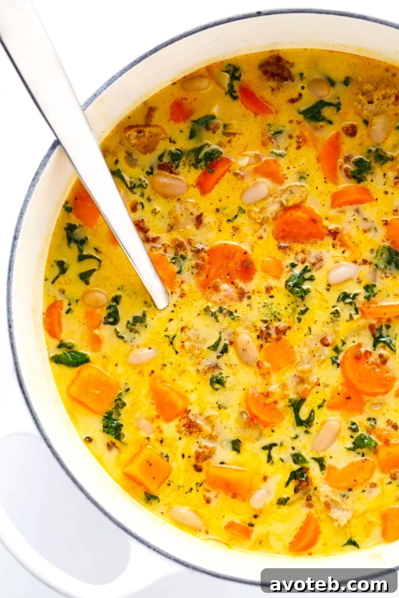 A large pot of Creamy Sweet Potato and Sausage Soup, brimming with vegetables and savory broth. | gimmesomeoven.com Creamy Sweet Potato and Sausage Soup simmering in a large stockpot