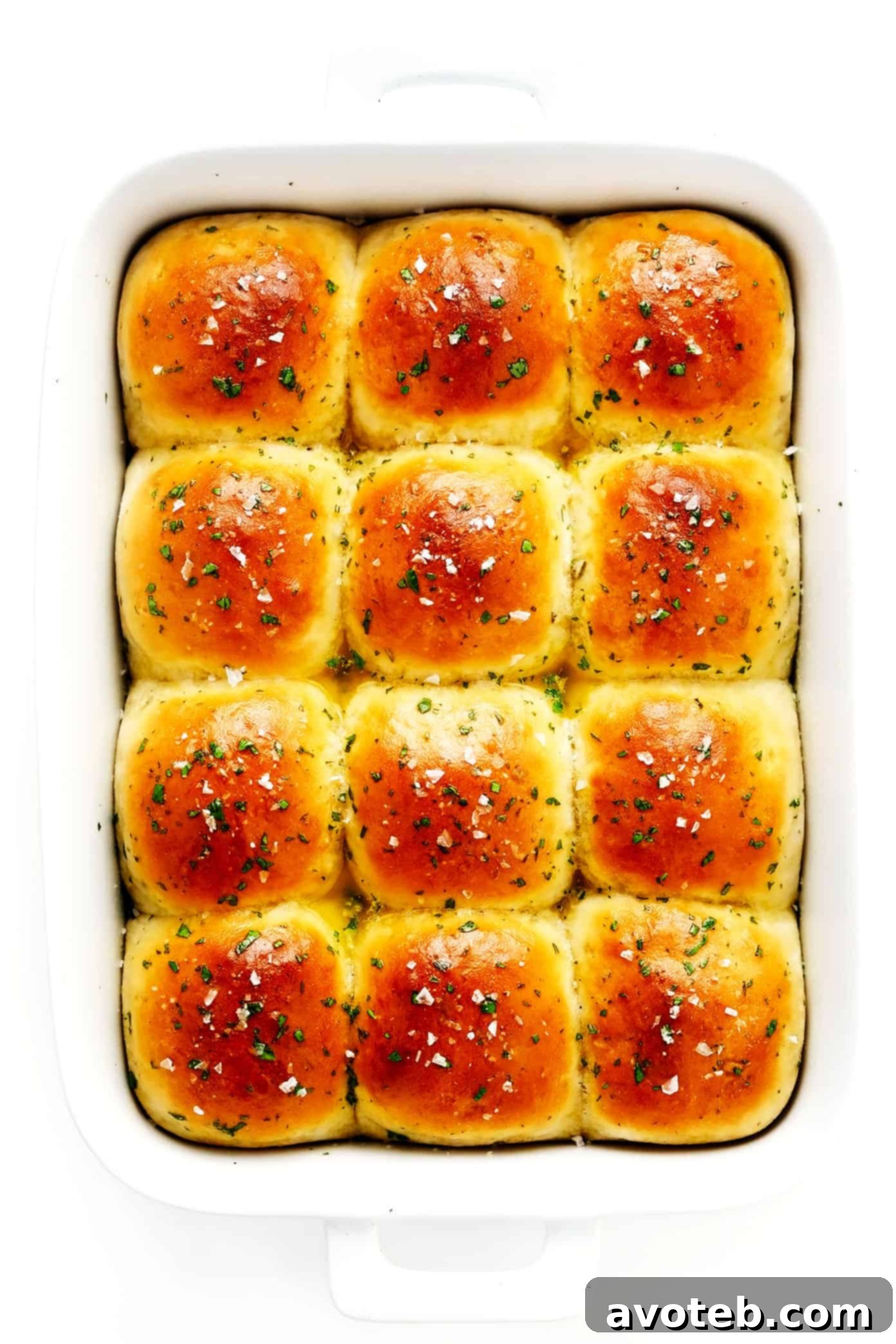 Rosemary Garlic Dinner Rolls in Pan - A baking dish filled with golden-brown rosemary garlic dinner rolls, fresh out of the oven, waiting to be enjoyed.