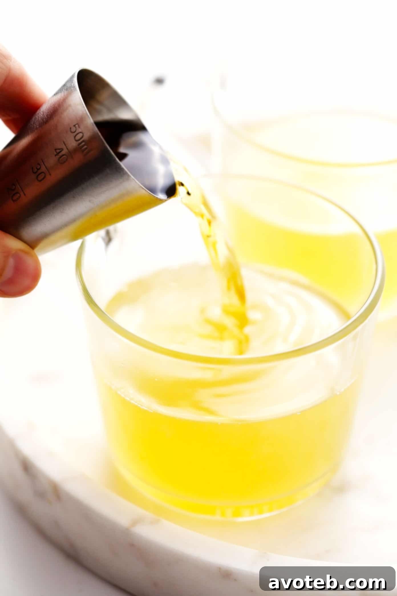 Demonstration of how to make a hot toddy, showing ingredients being combined in a mug.